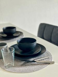einen Tisch mit zwei schwarzen Platten und einem Glas in der Unterkunft New Studio Cosy - Proche RER et centre ville in Brétigny-sur-Orge