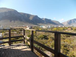 a wooden deck with a view of the mountains at Avondsrus Guesthouse in Bettyʼs Bay