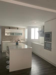 a white kitchen with a sink and a stove at Increíble piso céntrico in Gandía