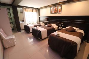 una camera d'albergo con tre posti letto di Hotel Frontera a Tacna