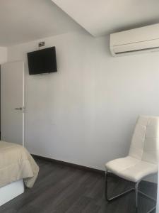 - une chambre avec un lit, une chaise et une télévision dans l'établissement Increíble piso céntrico, à Gandía