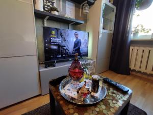 a living room with a tv and a coffee table at Niewielki pokój dla jednej osoby lub pary. in Warsaw