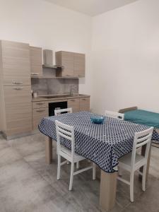 a kitchen with a table and chairs and a kitchen with a bed at TOTI&MARY HOME in Partinico