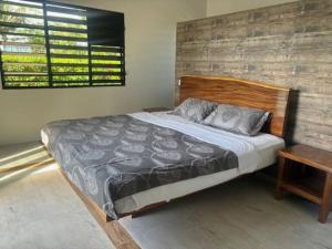 een slaapkamer met een groot bed met een houten hoofdeinde bij Harmonious Bella Villa in Pacific Harbour
