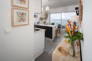 una cocina con una mesa con un jarrón de flores en Casa Da Praia, en Porto Formoso