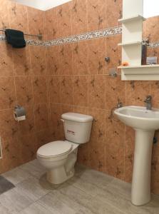 een badkamer met een toilet en een wastafel bij New Haven Guesthouse in Sosúa