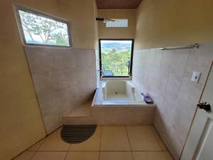 baño con bañera y ventana en Suite Frente a la Cascada, en Tierras Morenas