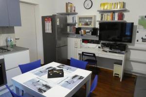 Il comprend une cuisine avec une table et des chaises bleues ainsi qu'une télévision. dans l'établissement Apartment il pescatore di sogni, à Pescara