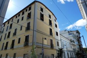un grand bâtiment jaune avec des fenêtres sur une rue dans l'établissement Apartment il pescatore di sogni, à Pescara