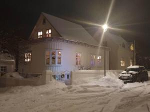 ein Haus mit einem Auto, das nachts im Schnee geparkt ist in der Unterkunft Charming apartment in Old town - great location in Reykjavík
