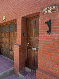 un edificio de ladrillo con 2 puertas de madera y una señal en Casa Los Nogales en Cafayate