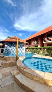 a swimming pool in front of a building at Suíte ACONCHEGO no Villa do porto a 300m do Beach Park e a 5 minutos a pé da praia in Aquiraz