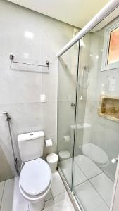 La salle de bains est pourvue de toilettes et d'une douche en verre. dans l'établissement Suíte ACONCHEGO no Villa do porto a 300m do Beach Park e a 5 minutos a pé da praia, à Aquiraz