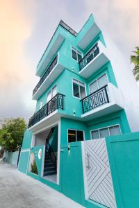 a blue building with balconies on top of it at Ukulhas Sands in Ukulhas