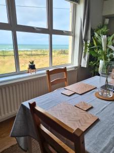 a dining room with a table with a view of the ocean at Portrush by the Sea - 6 Dunluce Park in Portrush
