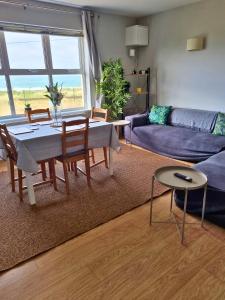 a living room with a table and a couch at Portrush by the Sea - 6 Dunluce Park in Portrush