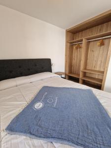 a bed with a blue towel on top of it at Hoy Caleta Apartments in Caleta De Fuste