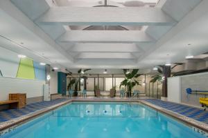 a swimming pool in a hotel room with a large ceiling at Crowne Plaza Kitchener-Waterloo by IHG in Kitchener
