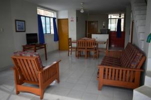 ein Wohnzimmer mit Holzstühlen und ein Esszimmer in der Unterkunft Punta Cocos Beach Casitas in Zorritos