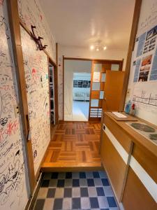 a kitchen with graffiti on the walls and a checkered floor at XXUFO in Atami