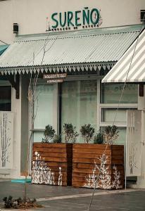 a store with a fence in front of a building at Sureño in Puerto Pirámides