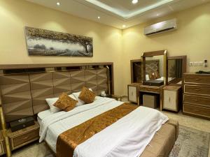 a bedroom with a large bed and a mirror at شقة فاخرة غرفتين وصالة النرجس ١٣ in Riyadh