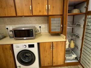 a kitchen with a microwave and a washing machine at شقة فاخرة غرفتين وصالة النرجس ١٣ in Riyadh