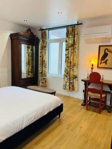 a bedroom with a bed and a chair and a window at Maison Georges in Tourcoing +70 photos