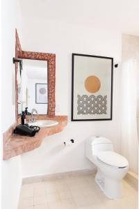 a bathroom with a toilet and a sink and a mirror at 1BR one block away to a beautiful beach in Puerto Vallarta