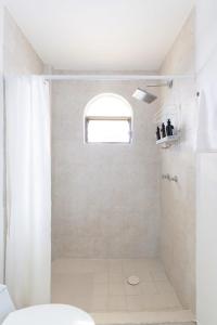 a bathroom with a shower with a toilet and a window at 1BR one block away to a beautiful beach in Puerto Vallarta