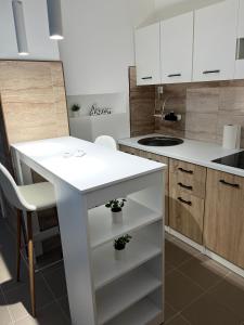 a kitchen with a white island in a room at Central Apartments 3 in Zaječar