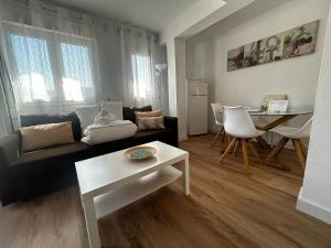 - un salon avec un canapé et une table dans l'établissement Apartamentos Morgan, à Malaga