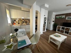 un salon avec une table en verre et une cuisine dans l'établissement Apartamentos Morgan, à Malaga
