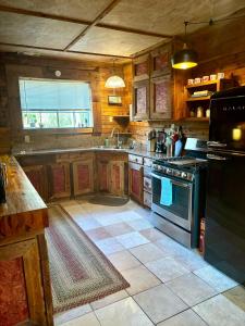 a kitchen with wooden cabinets and a stove top oven at The Cedar House - Huntsville Cultural District in Huntsville