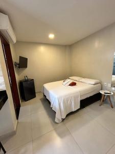 a hotel room with a bed and a tv at Morada do Sol Suítes in Arraial do Cabo