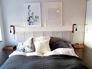 ein Bett in einem Schlafzimmer mit zwei Bildern an der Wand in der Unterkunft Stilvolles Appartement in Kaufbeuren