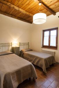two beds in a room with a wooden ceiling at Casa Camporino in Poppi