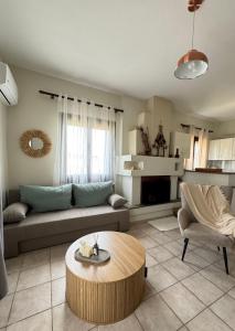 ein Wohnzimmer mit einem Sofa und einem Couchtisch in der Unterkunft Aurora Pelion Guest House in Kato Gatzea