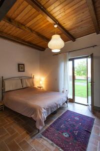 a bedroom with a large bed with a large window at Casa Camporino in Poppi