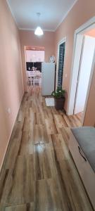 uma sala de estar com pisos em madeira e uma cozinha em Perla Apartment 1 em Golem