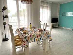 a dining room table and chairs with a tablecloth with a bottle on it at Lara's Apartment in Lido di Camaiore