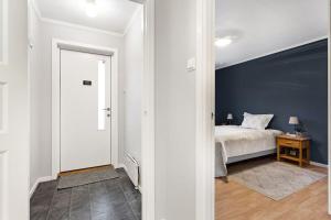 1 dormitorio con cama y pared azul en Cozy and central home near Oslo Gardermoen Airport en Eidsvoll