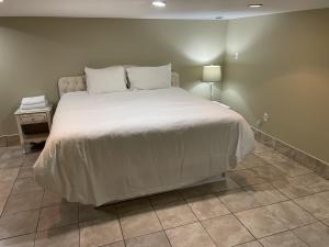 a bedroom with a large bed with a white comforter at Tranquility near the River Complimentary Breakfast in Niagara Falls