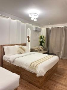 una camera da letto con un grande letto con lenzuola bianche di Sandy Heaven Maldives a Gulhi
