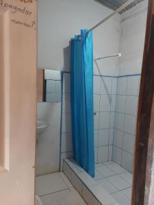リバスにあるHostal Brisas del Ometepeのバスルーム(青いシャワーカーテン付きのシャワー付)