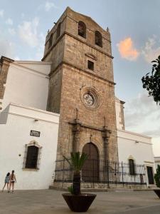 two people walking in front of a church at Casa rural Santa María del Castillo in Olivenza