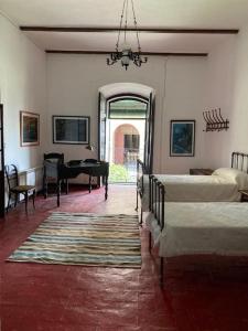 a bedroom with two beds and a grand piano at Casa rural Santa María del Castillo in Olivenza