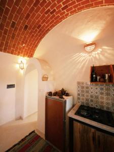 a kitchen with a stove and a brick ceiling at Douira S+1 in Chebba