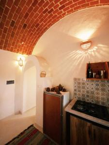 a kitchen with a stove and a brick ceiling at Douira S+1 in Chebba +9 photos