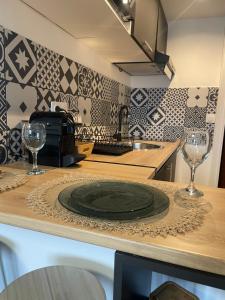 una cocina con un plato y dos copas de vino en una barra en Charmant studio place Stanislas, en Nancy